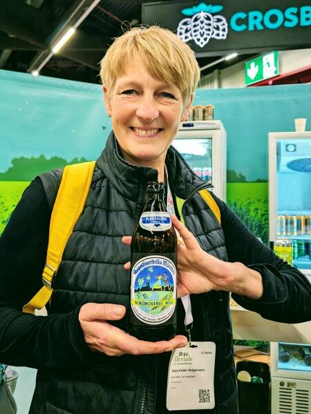 Bierflasche von Augustiner in der Hand mit traditionellem Etikett.